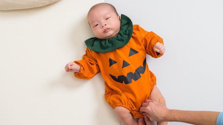 En baby i en jack-o-lantern-byxa.