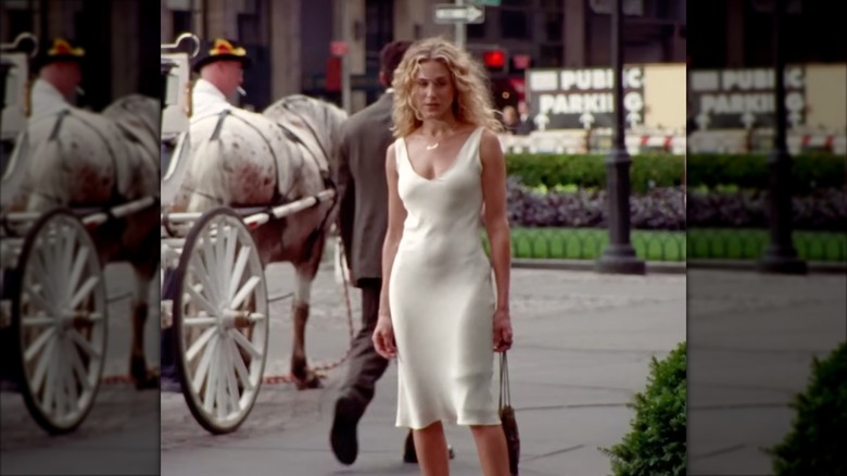 Sarah Jessica Parker som Carrie Bradshaw iklädd en off-white satinklänning.