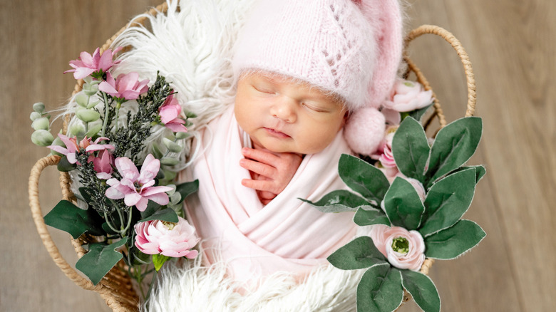En flicka som sover i en korg med blommor