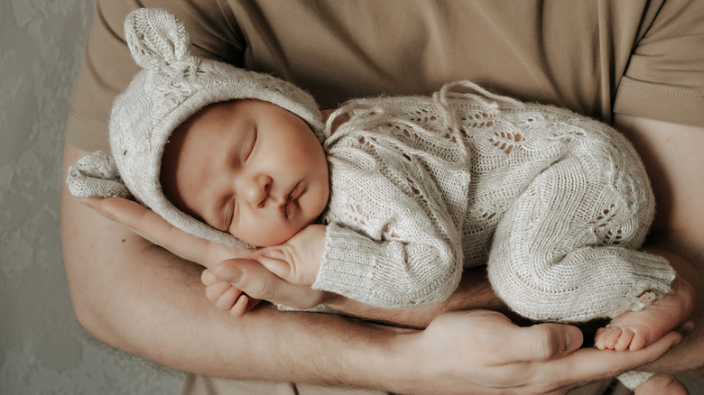 En nyfödd bebis som vaggas i någons famn