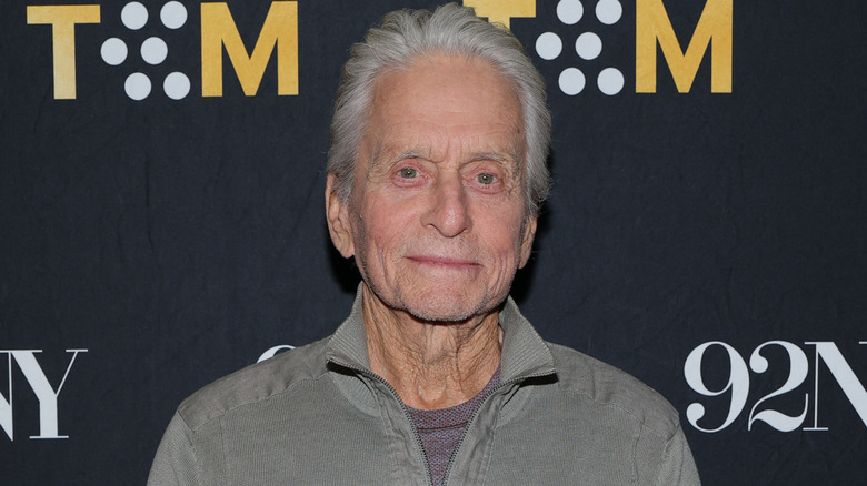 Michael Douglas klädd i en grå outfit på en röd matta