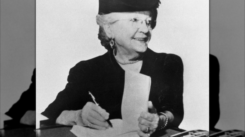 svartvitt foto av Laura Ingalls Wilder som signerar en bok
